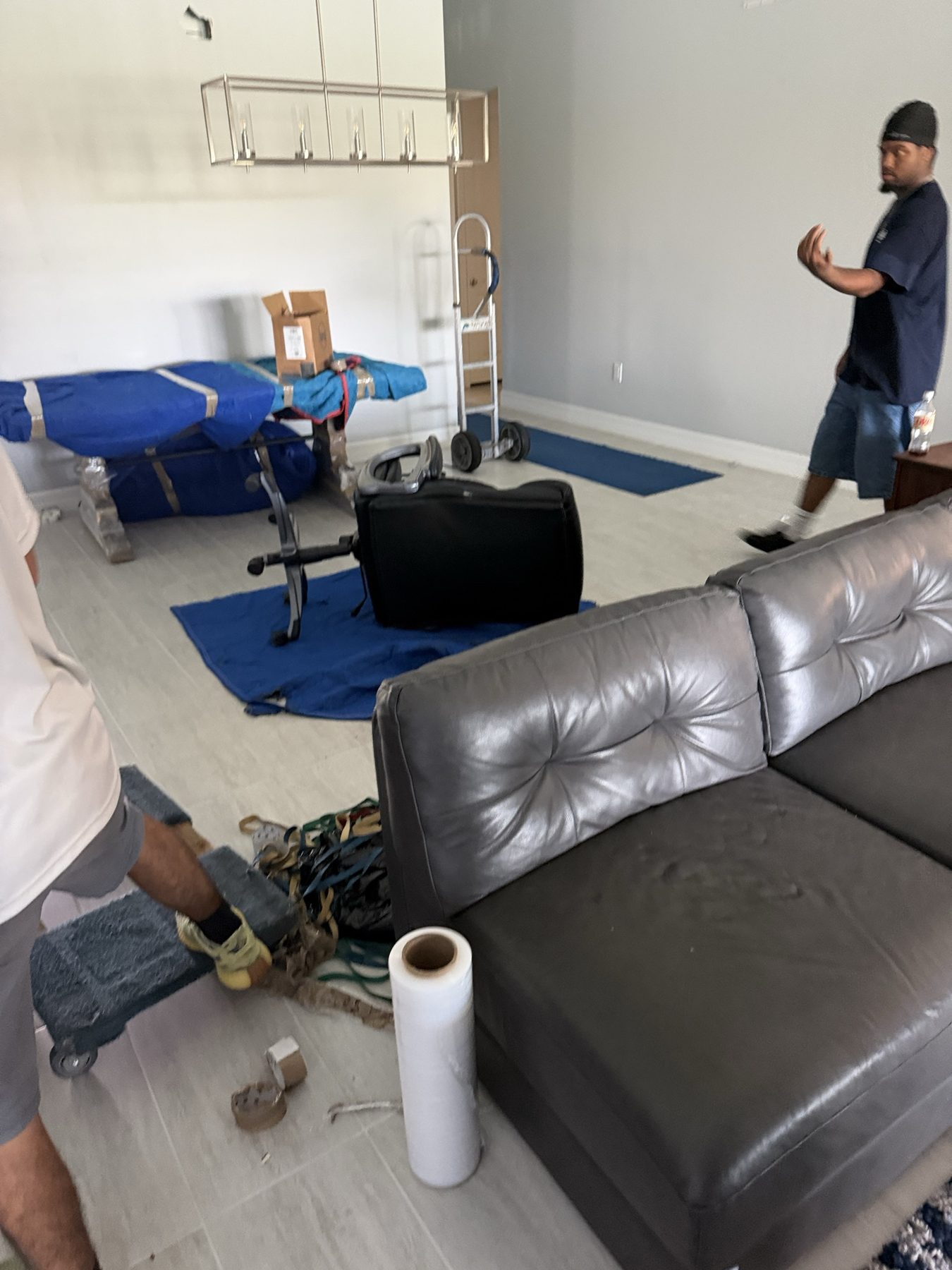 Two Tailwind Movers crew members moving furniture out of a home
