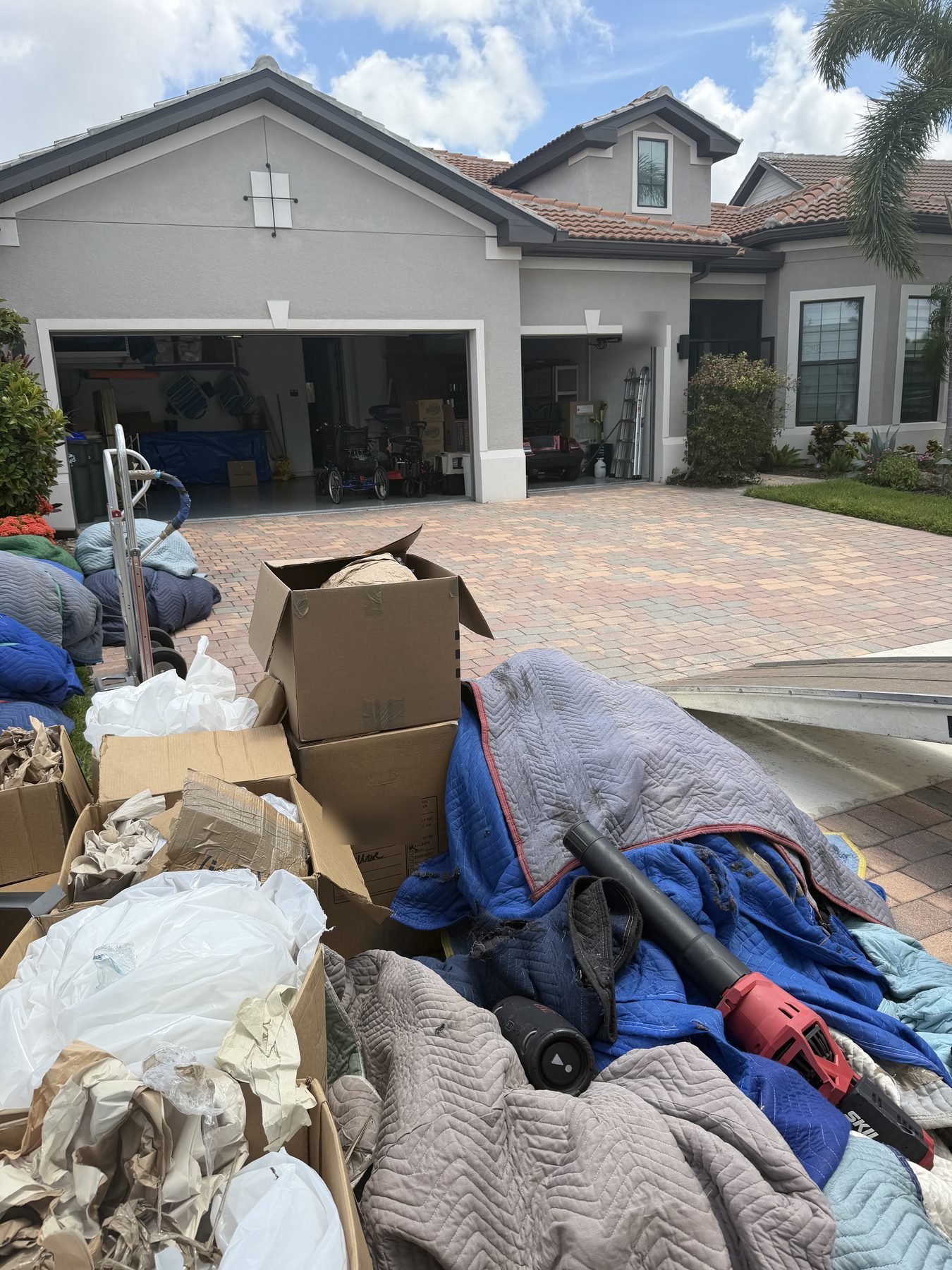 Boxes and bagged items staged curbside for a Tailwind Movers haul-away