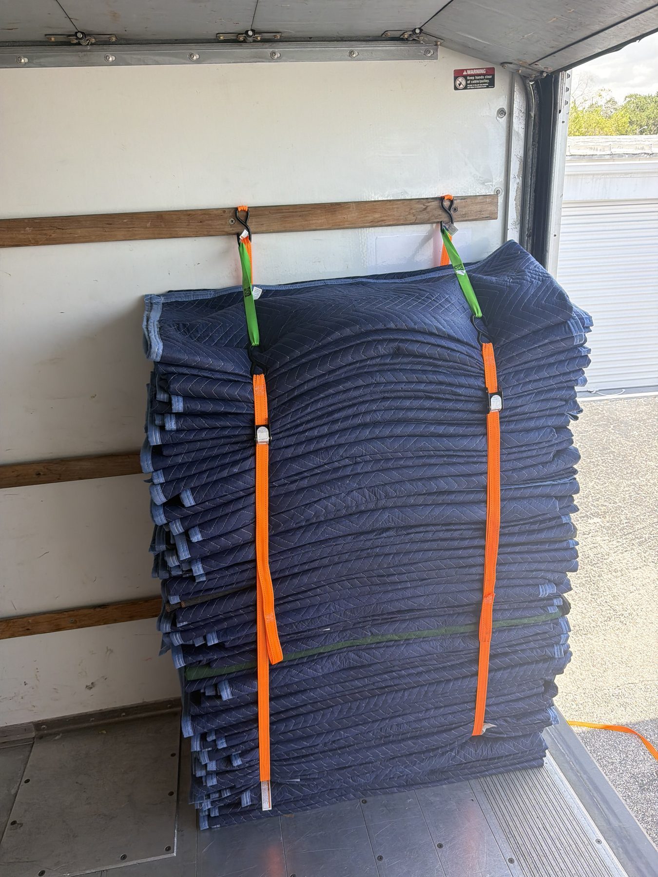 Moving blankets stacked and strapped in the Tailwind Movers truck
