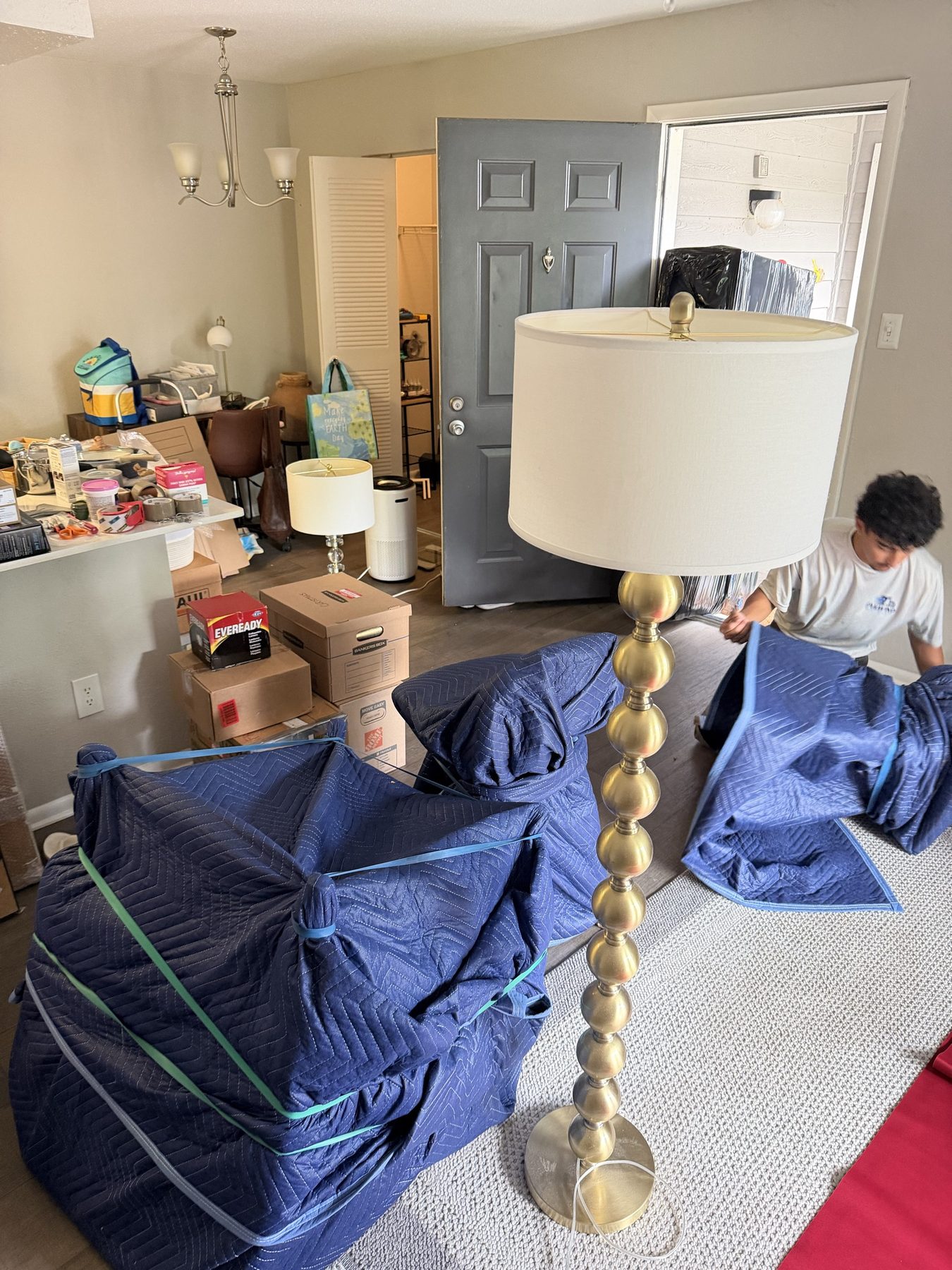 Wrapped furniture staged on a hand dolly in a garage